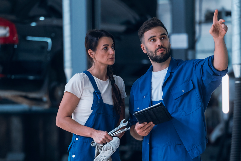 Patrão e funcionário trabalhando em conjunto em retenção de funcionários em oficina mecânica.