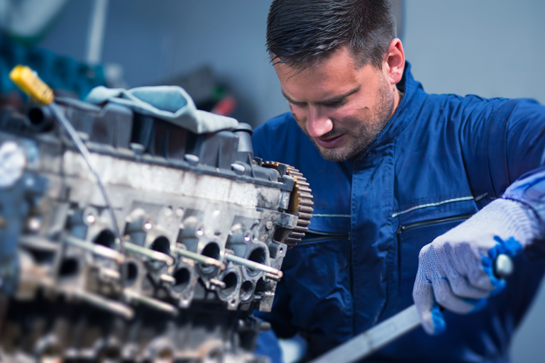 Homem com boa gestão de tempo na oficina mecânica trabalhando em um carro